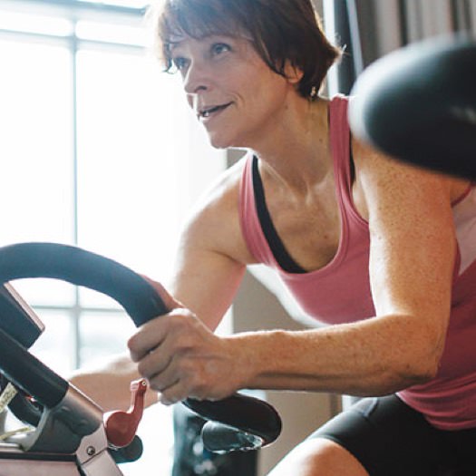Older woman exercising on a stationary cycle