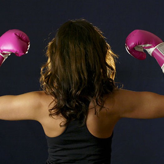 Woman standing with boxing gloves raised